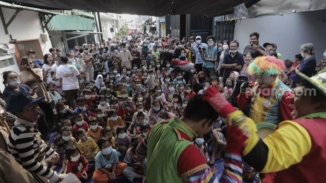 Anggota komunitas Aku Badut Indonesia (ABI) menghibur anak-anak korban kebakaran di Keagungan, Taman Sari, Jakarta, Kamis (22/4/2021). [Suara.com/Angga Budhiyanto]