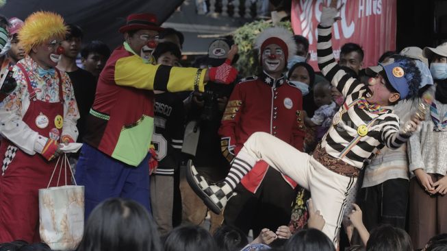 Anggota komunitas Aku Badut Indonesia (ABI) menghibur anak-anak korban kebakaran di Keagungan, Taman Sari, Jakarta, Kamis (22/4/2021). [Suara.com/Angga Budhiyanto]