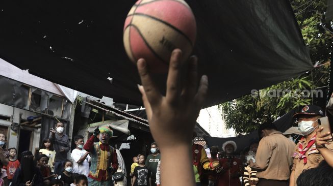 Anggota komunitas Aku Badut Indonesia (ABI) menghibur anak-anak korban kebakaran di Keagungan, Taman Sari, Jakarta, Kamis (22/4/2021). [Suara.com/Angga Budhiyanto]