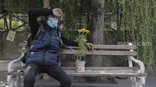 Aktivis lingkungan hidup membawa instalasi tanaman sebagai penyuplai oksigen saat menggelar aksi "Joget Jagat" di Jalan MH Thamrin, Jakarta, Kamis (22/4/2021). [Suara.com/Angga Budhiyanto]