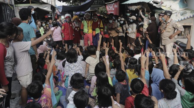 Anggota komunitas Aku Badut Indonesia (ABI) menghibur anak-anak korban kebakaran di Keagungan, Taman Sari, Jakarta, Kamis (22/4/2021). [Suara.com/Angga Budhiyanto]