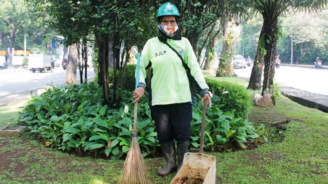 Ibu Asiah salah satu petugas kebersihan perempuan di Jalan Medan Merdeka Selatan, Jakarta Pusat, Kamis (22/4/2021). [Suara.com/Dian Latifah]
