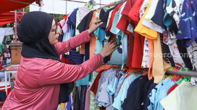 Warga memilih baju yang dijual di stand bazar ramadhan Taman Mini Indonesia Indah, Jakarta Timur, Sabtu (24/4/2021). [Suara.com/Alfian Winanto]