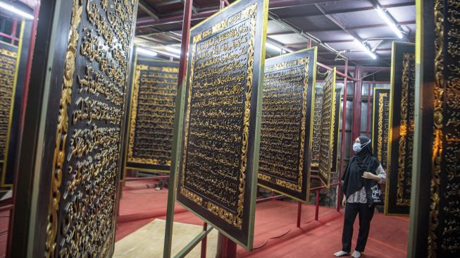 Pengunjung membaca ayat-ayat yang ada di Al Quran Al-Akbar di Palembang, Sumatera Selatan, Jumat (23/4/2021).  ANTARA FOTO/Nova Wahyudi