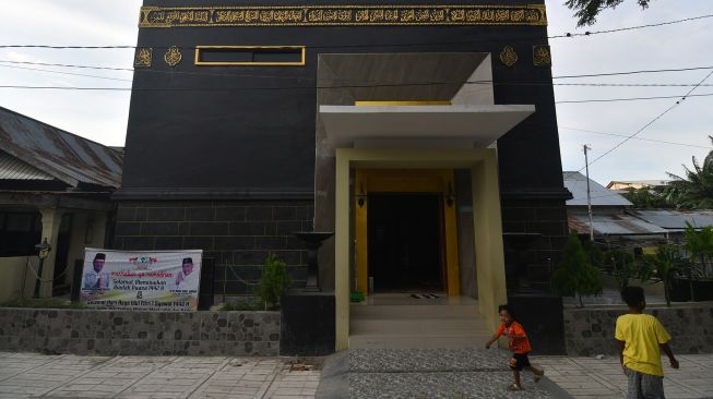 Sejumlah bocah bermain di depan Masjid Baiturrahim yang berarsitektur Kabah di Jalan Sarikaya di Palu, Sulawesi Tengah, Jumat (23/4/2021). ANTARA FOTO/Mohamad Hamzah