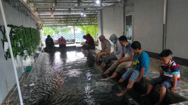 Asyiknya Sensasi Terapi Kaki dengan Ikan-Ikan Jelang Berbuka Puasa