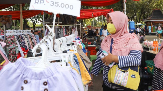 Warga memilih baju yang dijual di stand bazar ramadhan Taman Mini Indonesia Indah, Jakarta Timur, Sabtu (24/4/2021). [Suara.com/Alfian Winanto]