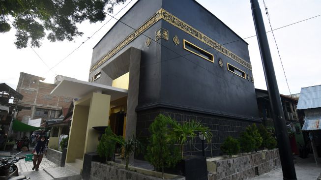 Warga berjalan di depan Masjid Baiturrahim yang berarsitektur Kabah di Jalan Sarikaya di Palu, Sulawesi Tengah, Jumat (23/4/2021). ANTARA FOTO/Mohamad Hamzah