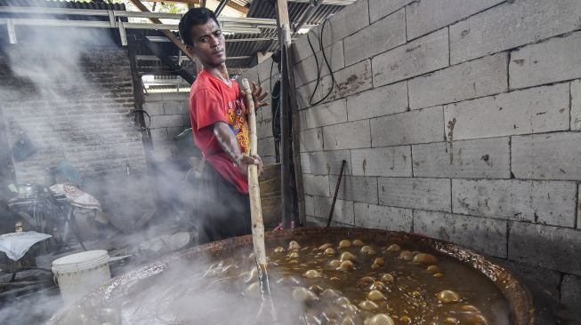 Seorang pekerja mengaduk dodol dalam kuali di rumah produksi Empat Saudara, Desa Sukajaya, Cibitung, Kabupaten Bekasi, Jawa Barat, Minggu (25/4/2021). [ANTARA FOTO/Fakhri Hermansyah]