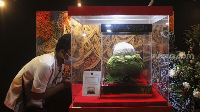 Pengunjung mengamati serban Nabi Muhammad yang dipamerkan dalam Pameran Artefak Nabi Muhammad SAW di Jakarta Islamic Center, Koja, Jakarta, Minggu (25/4/2021). [Suara.com/Dian Latifah]