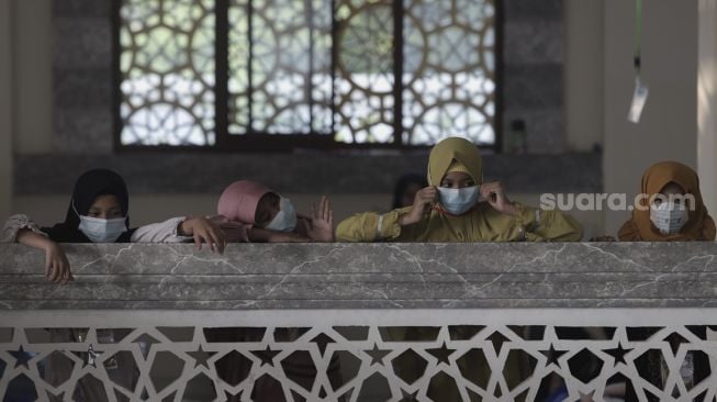 Santriwati bersiap mengikuti kegiatan Pesantren Kilat yang diselenggarakan pengurus Masjid An-Nur, Mampang Prapatan, Jakarta, Minggu (25/4/2021). [Suara.com/Angga Budhiyanto]