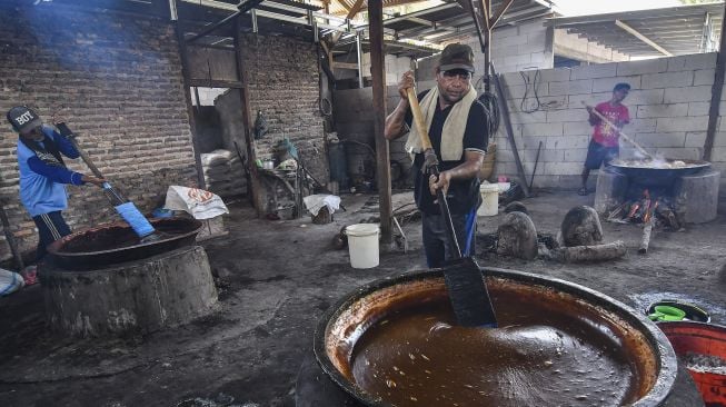 Sejumlah pekerja mengaduk dodol dalam kuali di rumah produksi Empat Saudara, Desa Sukajaya, Cibitung, Kabupaten Bekasi, Jawa Barat, Minggu (25/4/2021). [ANTARA FOTO/Fakhri Hermansyah]