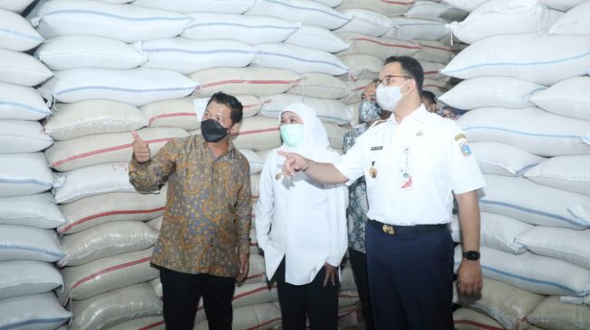 Gubernur Jawa Timur, Khofifah Indar Parawansa dan Gubernur DKI Jakarta Anies Baswedan meninjau gudang beras di Kabupaten Ngawi usai penandatanganan MoU bersama antara Pemkab Ngawi dengan PT Food Station Tjipinang Jaya dalam rangka pemenuhan kebutuhan stok beras DKI Jakarta, Minggu (25/4/2021).