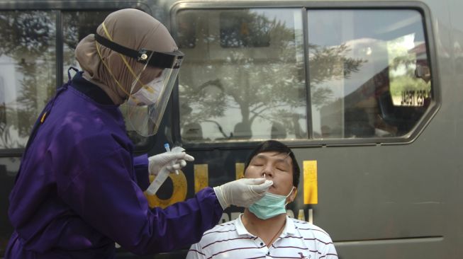 Petugas medis mengambil sampel untuk swab Antigen pengendara saat pengetatan dan pengamanan mudik di rest area KM 275, Penarukan, Kabupaten Tegal, Jawa Tengah, Senin (26/4/2021). [ANTARA FOTO/Oky Lukmansyah]