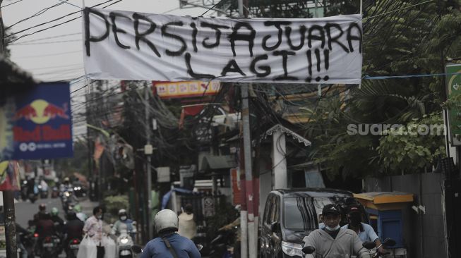 Spanduk Persija Jakarta juara Piala Menpora 2021 terpasang di kawasan Pancoran, Jakarta, Senin (26/4/2021). [Suara.com/Angga Budhiyanto]