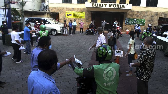 Panitia penyelenggara membagikan takjil secara Drive Thru di GPIB Bukit Moria, Jalan Prof.Dr.Soepomo, Kecamatan Tebet, Jakarta Selatan, Senin (26/4/2021). [Suara.com/Dian Latifah]