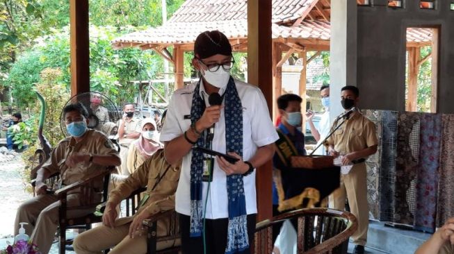 Menteri Pariwisata dan Ekonomi Kreatif, Sandiaga Salahudin Uno memberi keterangan kepada pelaku usaha dan pengrajin di Sanggar Peni dalam kunjungan desa wisata di  Krebet, Kalurahan Sendangsari, Kapanewon Pajangan, Bantul, Senin (26/4/2021). [Muhammad Ilham Baktora / SuaraJogja.id]