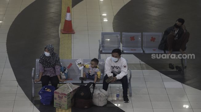 Calon penumpang menunggu kedatangan bus di Terminal Pulo Gebang, Jakarta Timur, Selasa (27/4/2021). [Suara.com/Angga Budhiyanto]