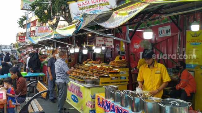 Warga memadati Food Street Kramat untuk mencari menu berbuka puasa di Kawasan Senen, Jakarta Pusat, Selasa (27/4/2021). [Suara.com/Alfian Winanto]