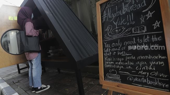 Warga memilih koleksi buku di perpustakaan bersama Bookhive Jakarta di kawasan Taman Situ Lembang, Jakarta, Selasa (27/4/2021). [Suara.com/Angga Budhiyanto]