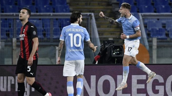 Penyerang Lazio Ciro Immobile (kanan) melakukan selebrasi setelah mencetak gol selama pertandingan sepak bola Serie A Italia antara Lazio melawan AC Milan di Stadion Olimpico, Selasa (27/4/2021) dini hari WIB.  [Filippo MONTEFORTE / AFP]