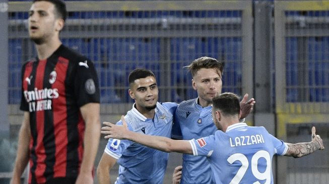 Penyerang Lazio Ciro Immobile (kanan) melakukan selebrasi setelah mencetak gol selama pertandingan sepak bola Serie A Italia antara Lazio melawan AC Milan di Stadion Olimpico, Selasa (27/4/2021) dini hari WIB.  [Filippo MONTEFORTE / AFP]