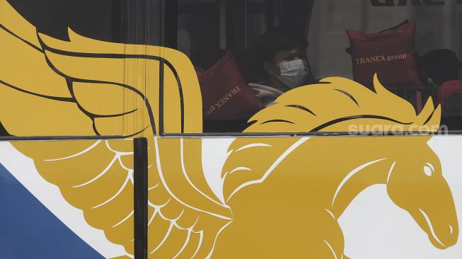 Penumpang dengan mengenakan masker berada di dalam bus di Terminal Pulo Gebang, Jakarta Timur, Selasa (27/4/2021). [Suara.com/Angga Budhiyanto]