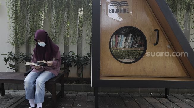 Warga membaca buku di perpustakaan bersama Bookhive Jakarta di kawasan Taman Situ Lembang, Jakarta, Selasa (27/4/2021). [Suara.com/Angga Budhiyanto]