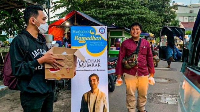 Anggota Manchester City Supporters Club Indonesia (MCSCI) membagi-bagikan takjil yang merupakan donasi langsung dari gelandang Manchester City asal Jerman, Ilkay Gundogan. (HO/MCSCI)