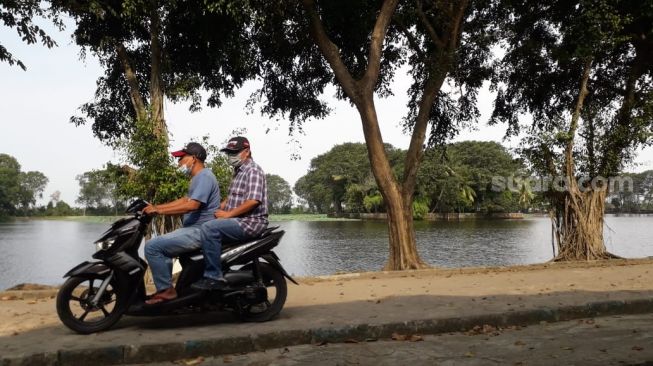 Warga melintas di bagian dalam taman rekreasi Tasikardi [Suara.com/ Adi Mulyadi]