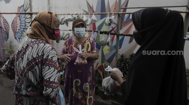 Warga memilah sayuran yang dijajakan secara gratis di Jalan Jati Padang VI RT 002 RW 004, Pasar Minggu, Jakarta Selatan, Rabu (28/4/2021). [Suara.com/Angga Budhiyanto]