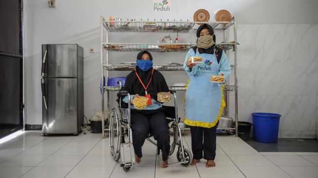 Dua orang siswa disabilitas menunjukan kue buatannya saat pelatihan pembuatan kue lebaran bagi disabilitas di Panti Sosial Rehabilitasi Penyandang Disabilitas, Dinas Sosial Provinsi Jawa Barat di Cimahi, Jawa Barat, Rabu (28/4/2021). ANTARA FOTO/Raisan Al Farisi