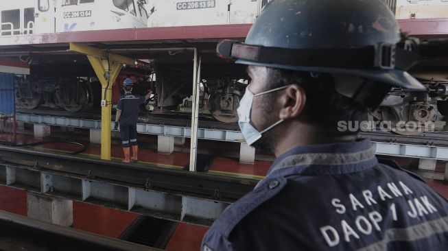 Pekerja beraktivitas melakukan perawatan rutin pada lokomotif di Depo Kereta Cipinang, Jakarta, Kamis (29/4/2021). [Suara.com/Angga Budhiyanto]