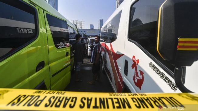 Pemilik kendaraan travel gelap menunggu hasil pemeriksaan usai diamankan petugas Kepolisian di Lapangan Presisi Ditlantas PMJ, Jakarta, Kamis (29/4/2021). ANTARA FOTO/Muhammad Adimaja/foc.