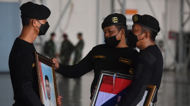 Prajurit Kapal Selam TNI AL memegang foto prajurit KRI Nanggala-402 yang gugur saat Penganugerahan tanda kehormatan dan kenaikan pangkat luar biasa prajurit KRI Nanggala-402 di Hanggar Lanudal Juanda Surabaya di Sidoarjo, Jawa Timur, Kamis (29/4/2021). ANTARA FOTO/Zabur Karuru
