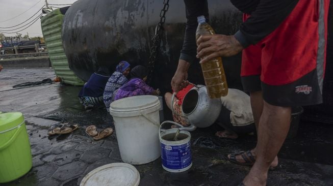 Warga mengambil minyak dari sebuah truk tangki yang mengalami kecelakaan di Jalur Pantura Sipait, Kabupaten Pekalongan, Jawa Tengah, Kamis (29/4/2021). ANTARA FOTO/Harviyan Perdana Putra