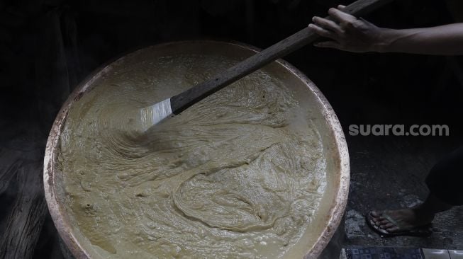 Pekerja mengaduk adonan dodol Betawi di Pondok Dodol Sari Rasa Ibu Yuyun di kawasan Pasar Minggu, Jakarta Selatan, Jumat (30/4/2021). [Suara.com/Angga Budhiyanto]