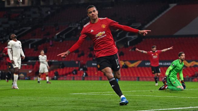 Striker Manchester United Mason Greenwood merayakan golnya setelah mencetak gol keenam selama pertandingan sepak bola leg pertama semifinal Liga Europa antara Manchester United melawan Roma di Old Trafford, Jumat (30/4/2021) dini hari WIB. Paul ELLIS / AFP