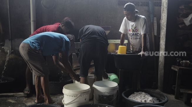 Pekerja menyiapkan adonan dodol Betawi di Pondok Dodol Sari Rasa Ibu Yuyun di kawasan Pasar Minggu, Jakarta Selatan, Jumat (30/4/2021). [Suara.com/Angga Budhiyanto]