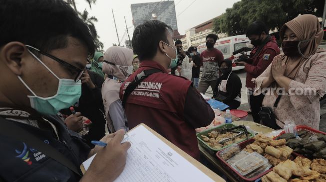 Petugas Puskesmas Gambir melakukan pendataan makanan dari pedagang takjil untuk uji laboratorium di kawasan Petojo Utara, Gambir, Jakarta Pusat, Jumat (30/4/2021). [Suara.com/Angga Budhiyanto]