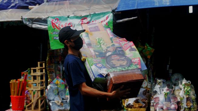 Penjual membawa parsel di Jalan Pegangsaan Timur, Cikini, Jakarta Pusat, Jumat (30/4/2021).  [Suara.com/Dian Latifah]
