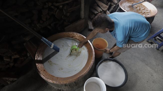 Pekerja menyiapkan adonan dodol Betawi di Pondok Dodol Sari Rasa Ibu Yuyun di kawasan Pasar Minggu, Jakarta Selatan, Jumat (30/4/2021). [Suara.com/Angga Budhiyanto]