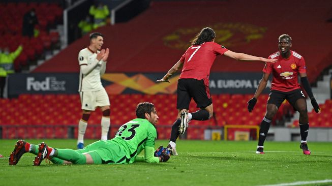 Striker Manchester United Edinson Cavani mencetak gol ketiga selama pertandingan sepak bola leg pertama semifinal Liga Europa antara Manchester United melawan Roma di Old Trafford, Jumat (30/4/2021) dini hari WIB. Paul ELLIS / AFP