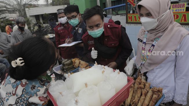 Petugas Puskesmas Gambir melakukan pendataan makanan dari pedagang takjil untuk uji laboratorium di kawasan Petojo Utara, Gambir, Jakarta Pusat, Jumat (30/4/2021). [Suara.com/Angga Budhiyanto]