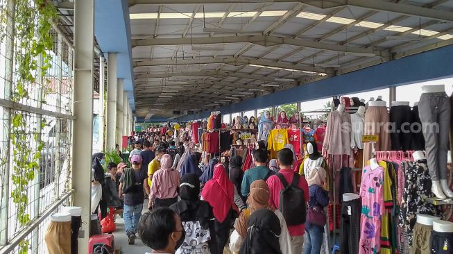 Warga memadati kawasan Skybridge atau jembatan penyeberangan multiguna untuk berbelanja di Pasar Tanah Abang, Jakarta Pusat, Sabtu (1/5/2021). [Suara.com/Alfian Winanto]