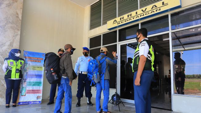 Petugas memeriksa suhu tubuh penumpang saat tiba di Bandar Udara Cut Nyak Dhien Kabupaten Nagan Raya, Aceh, Sabtu (1/5/2021). ANTARA FOTO/Syifa Yulinnas
