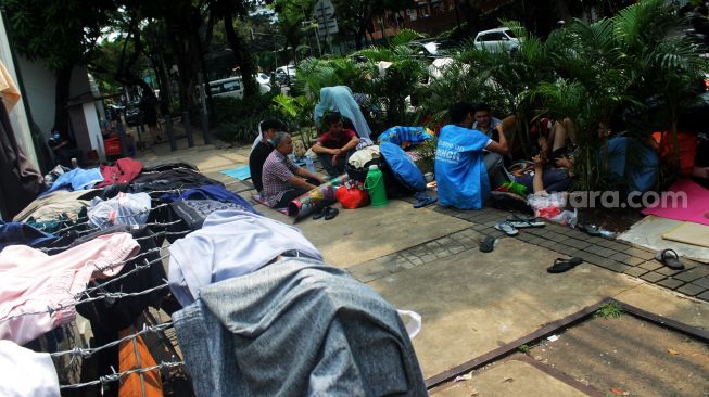 Sejumlah pencari suaka beraktivitas di trotoar depan kantor UNHCR, Jalan Kebon Sirih, Jakarta, Jumat (30/4/2021).  [Suara.com/Dian Latifah]