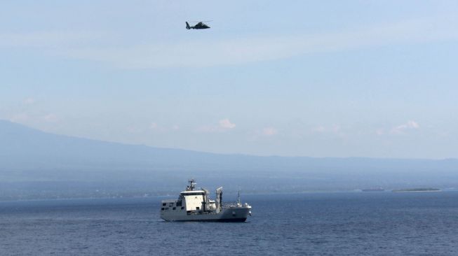 Helikopter terbang di atas KRI Bontang 907 yang memantau posisi KRI Nanggala 402 di perairan utara pulau Bali, Bali, Jumat (30/4/2021). ANTARA FOTO/Budi Candra Setya