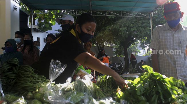 Warga mengambil sayuran saat kegiatan bazar sayuran gratis di Masjid Ar Ruhama, Jati Padang, Jakarta, Minggu (2/5/2021). [Suara.com/Dian Latifah]