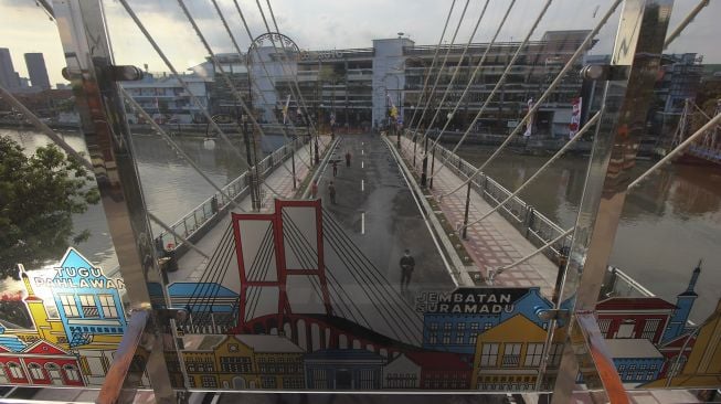 Warga menikmati suasana di Jembatan Sawunggaling, Surabaya, Jawa Timur, Sabtu (1/5/2021). [ANTARA FOTO/Didik Suhartono]